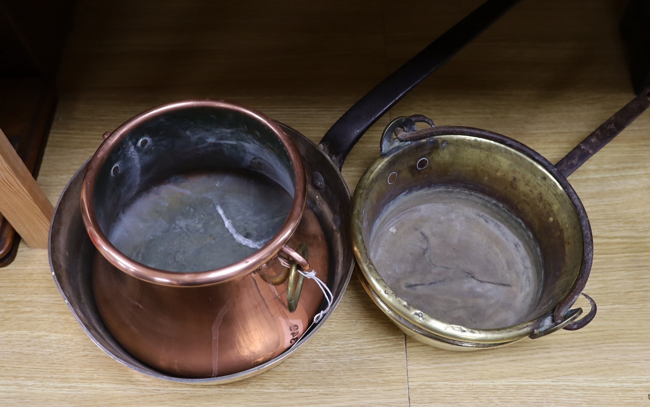 A French copper cooking pan, copper saucepan and two brass pans, largest 30cms diameter